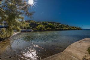 a view of a body of water with the sun in the sky at Villa Rossa Apartments in Rab