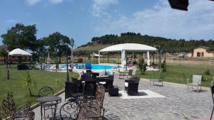 a patio with tables and chairs next to a pool at Agriturismo Fieri in Botricello