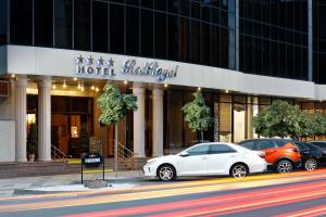 two cars parked in front of a hotel headquarters at Red Royal by Undersun in Krasnodar