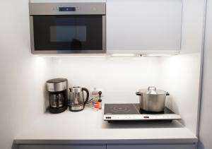 a kitchen counter with a stove and a microwave at Waterland Hoge Huis in Monnickendam +26 photos