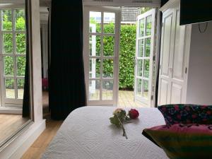 een slaapkamer met een bed met een boeket bloemen erop bij Place To Be in Naarden