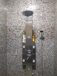 łazienka z prysznicem i ścianą wyłożoną kafelkami. w obiekcie seoul hotel w mieście Szymkent