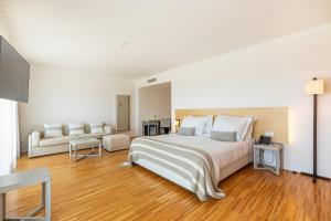 Algarve Race Resort - Hotel في Montes de Cima: غرفة نوم بيضاء مع سرير كبير وأريكة