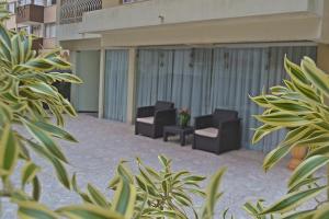 a courtyard with two chairs and plants in a building at Hotel Ampiezza in Curitiba