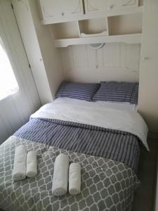 1 cama en una habitación pequeña con 2 almohadas en Domki obok plaży, en Moryń