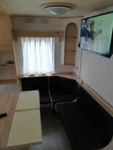 a living room with a couch and a flat screen tv at Domki obok plaży in Moryń