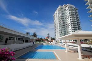 a swimming pool in front of a tall building at Bay Resort Condominium, 7, Beach-front Sea view, 6-8 PAX in Miri