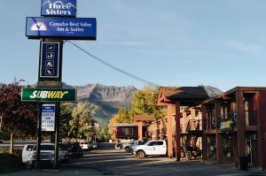 un letrero de la calle en una ciudad con montañas en el fondo en Canadas Best Value Inn and Suites Fernie en Fernie