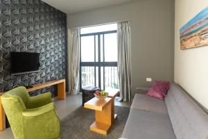 a living room with a couch and a tv at Hillel 11 Hotel in Jerusalem