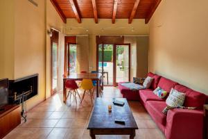 uma sala de estar com um sofá vermelho e uma mesa em Ca LaMari em Vidreres