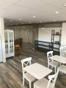 een wachtkamer met tafels en stoelen en een bed bij Við Hafið Guesthouse in Ólafsvík