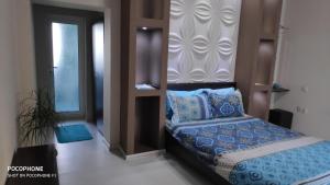 1 dormitorio con cama con sábanas azules y ventana en Georgievi Guest House, en Sapareva Banya
