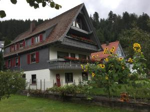 una casa con girasoles delante de ella en Ferienwohnung Pusteblume, en Alpirsbach