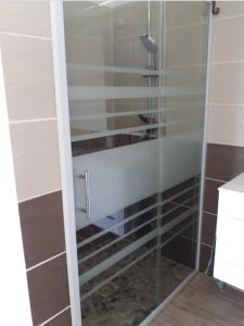 a shower with glass doors in a bathroom at Bungalow de charme in Capesterre-Belle-Eau