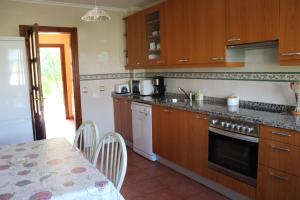 cocina con armarios de madera, mesa, mesa y comedor en Casa Rural El Gidio, en Parres de Llanes
