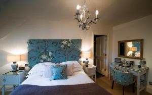 a bedroom with a large bed with a blue wall at The Swan Hotel in Bibury
