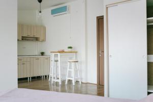 a kitchen with white cabinets and stools in a room at White & Wood in Bitola