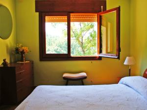 ein Schlafzimmer mit einem Bett, einem Fenster und einem Stuhl in der Unterkunft Casa El Prao in Arenas de San Pedro + 33 Fotos