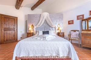 una camera con un letto bianco a baldacchino di " LE FORRI " società agricola a Pistoia