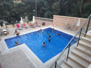 a group of people swimming in a swimming pool at Michaelangelo in Parga