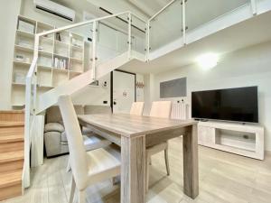 a dining room with a wooden table and white stairs at Future Apartments in Milan