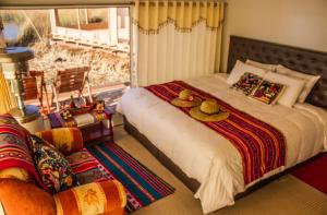 a bedroom with a large bed with two hats on it at Luz del Titicaca Lodge in Puno