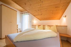 1 dormitorio con 1 cama grande y techo de madera en Alpenblick, en Valle di Casies