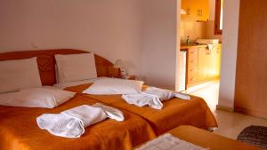 a bedroom with two beds with towels on them at Tria Adelphia in Arillas