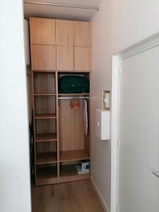 einem Schrank mit Holzschränken und einem Kühlschrank in der Unterkunft Studio Winston in Dinard