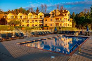 a large house with a swimming pool in front of a house at Westwood Shores Waterfront Resort in Sturgeon Bay