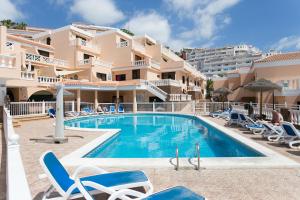 a swimming pool in front of a large apartment at Apartment Paradise Court in Adeje