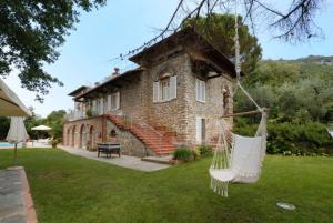 uma casa de pedra com uma rede em frente em Maison Brinati Bed and Breakfast em Monsummano