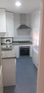 cocina con armarios blancos y fogones en Apartamento acogedor en lugar inmejorable, en Sanlúcar de Barrameda