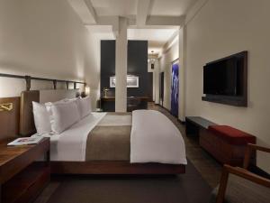 a hotel room with two beds and a television at Refinery Hotel - New York in New York