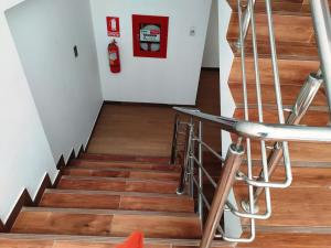 escalera con suelo de madera y extintor de incendios en Real House Cusco, en Cusco