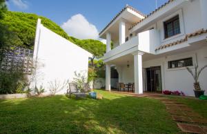 una casa bianca con una siepe verde di Casas Los 4 Soles a Los Caños de Meca