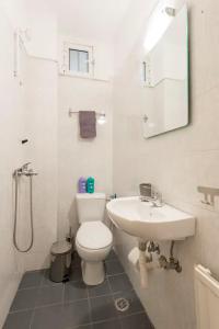 een witte badkamer met een toilet en een wastafel bij Saint Dimitrios Central Apartment 100sqm. in Thessaloniki