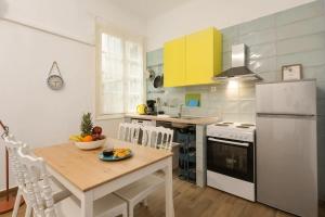 een keuken met een tafel en een witte koelkast bij Saint Dimitrios Central Apartment 100sqm. in Thessaloniki