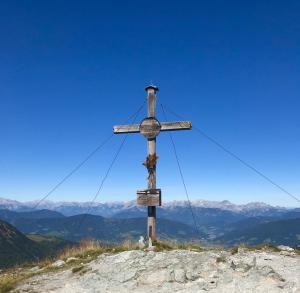 una cruz de madera en la cima de una montaña en Appartementhaus Sky Lodge, en Altenmarkt im Pongau