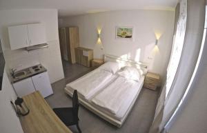 a small room with a bed and a kitchen at Pension Kochertal in Aalen