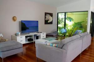 a living room with a couch and a tv at @LIZZIE in Elizabeth Beach