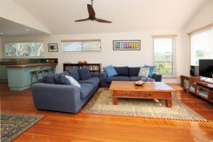 a living room with a blue couch and a coffee table at SPINNAKER 1 in Elizabeth Beach