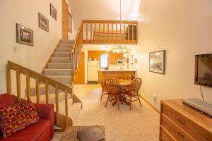 a living room with a staircase and a table and chairs at The Inn at Little Sister Hill in Sister Bay