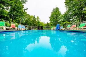 a large swimming pool with colorful chairs and trees at The Inn at Little Sister Hill in Sister Bay