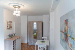 a living room with a table and a chandelier at Sweet Home in Belgrade