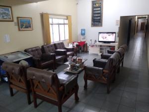 una sala de espera con sillas, mesa y TV en FRONTIER PALACE HOTEL en Ponta Porã