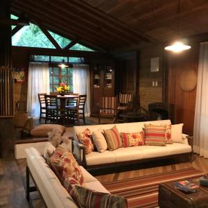 a living room with a white couch and a table at Regina Guest House in Praia do Rosa