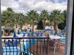 a view of the pool at a resort with palm trees at Paradise Apartments in Laganas