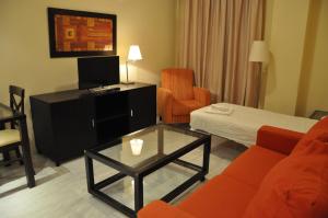 Apartamentos Luxsevilla Palacio في إشبيلية: غرفة معيشة مع أريكة وطاولة قهوة