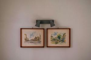 two pictures on a wall with a light above them at Loft Apartments in Komotini